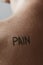 Man with the word pain in his back