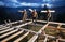 Man worker building wooden frame house on pile foundation.