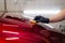 Man worker of car detailing studio applying ceramic coating on car paint with sponge applicator