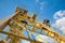 Man, worker, climbs up the stairs to the yellow crane industria