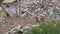 Man worker on excavator works on construction garbage dump.