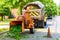 Man worker feeds large branch into wood chipper