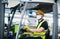 Man worker forklift driver with protective mask working in industrial factory or warehouse.