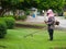 Man worker with a manual lawn mower mows the grass