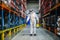 Man worker with protective mask and suit disinfecting industrial factory with spray gun.