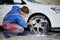 Man worker washing car`s alloy rims on a car wash