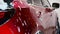 Man worker washing red car on a car wash with black glove.