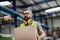 Man worker working in industrial factory or warehouse, carrying box.