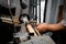 A man in a working apron works on a wood turning lathe.