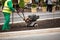 Man working in the city streets with Garden Tiller. Close-up male plow. Cultivator machine.