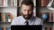 Man working at computer. Focused bearded male worker freelancer businessman salesman at workplace typing on laptop