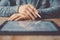 Man working contemporary electronic tablet while sitting at the wooden table at office.Blurred background. Horizontal