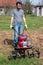 Man working in the garden with garden tiller. tractor cultivating and loosens soil field