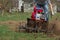 Man working in the garden with garden tiller. tractor cultivating and loosens soil field