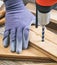 Man working with a hand drilling tool on the work bench