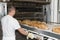 A man working with an industrial oven in a bakery