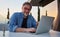 Man working with laptop at home office on balcony