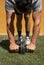 Man working out with  double wheel ab rollers outdoors below harsh sunlight on the orange background