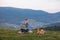 Man working outdoors with laptop sitting in mountains. Concept of remote work or freelancer lifestyle. Cellular network broadband