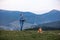 Man working outdoors with laptop standing in mountains. Concept of remote work or freelancer lifestyle. Cellular network broadband