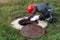 A man working plumber in overalls bent over a water well fixes the measurements made and the readings of the water meter