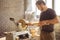 Man working at small wood lathe, an artisan carves piece of wood