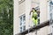 A man working standing on a scaffolding in the city center of Trondheim