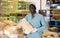 Man working in warehouse, carrying bag full of corn seeds