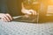 A man works at home using a laptop during teleworking during the coronavirus pandemic, male hands near the keyboard at the table