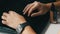 A man works at laptop. Men`s hands with a smart watch and an electronic cigarette are typing on the keyboard.