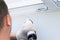 A man works with silicone sealant to insulate windows from dust and dirt in the house, top view