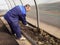 A man works in a vegetable garden in early spring. Digs the ground. Working in a greenhouse