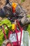 The man works by welding. A welder repairs an iron garden cart using electric welding