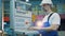 A man in workwear is operating a control panel