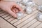 The man wraps peeled raw potatoes in foil and places them on the wire rack to bake them in oven.