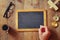 Man writes on a blank blackboard on wooden table