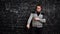 Man writes formula on chalkboard full of algebra equations and smiles crossing hands
