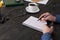 Man writes in a pad on a wooden table