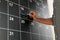 Man writing with chalk on board calendar, closeup