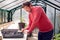 Man Writing Labels To Put In Seed Trays Growing In Greenhouse At Home