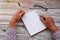 Man writing in notepad, using his left hand. Conceptual photo of lefthanded day. Mock up notepad. Top view. Copy space.