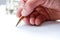 Man writing with pen on paper, close up of hand hollding pen to write on paper document