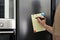 Man writing to do list on refrigerator door in kitchen, closeup. Space for text