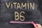 Man writing words Vitamin B6 on chalkboard