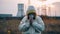 Man in yellow chemical protection suit and face protective mask Praying against the backdrop of a nuclear power plant