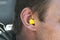 Man with yellow earplug in his ear