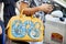 Man with yellow Gucci bag with blue snake design and white and black floral shirt before Les Hommes fashion show