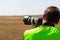 Man in yellow vest does plane spotting at the airport