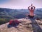 Man in yoga pose has picnic dinner in the wilderness in sunrise