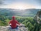 Man in yoga position in mountains above wild nature at sunset. Concept of meditation, spirituality and soul balance